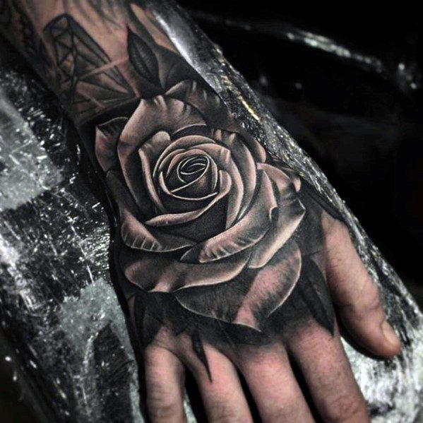 White and black rose tattoo on upper hand