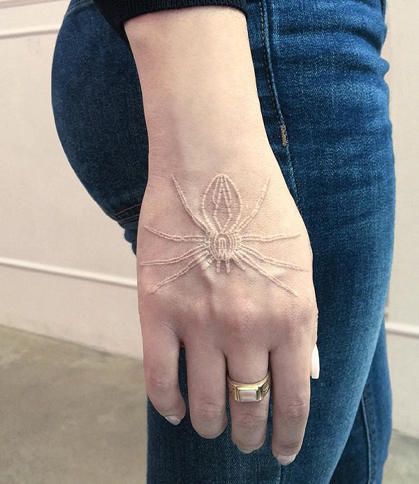 White ink spider tattoo on upper right hand