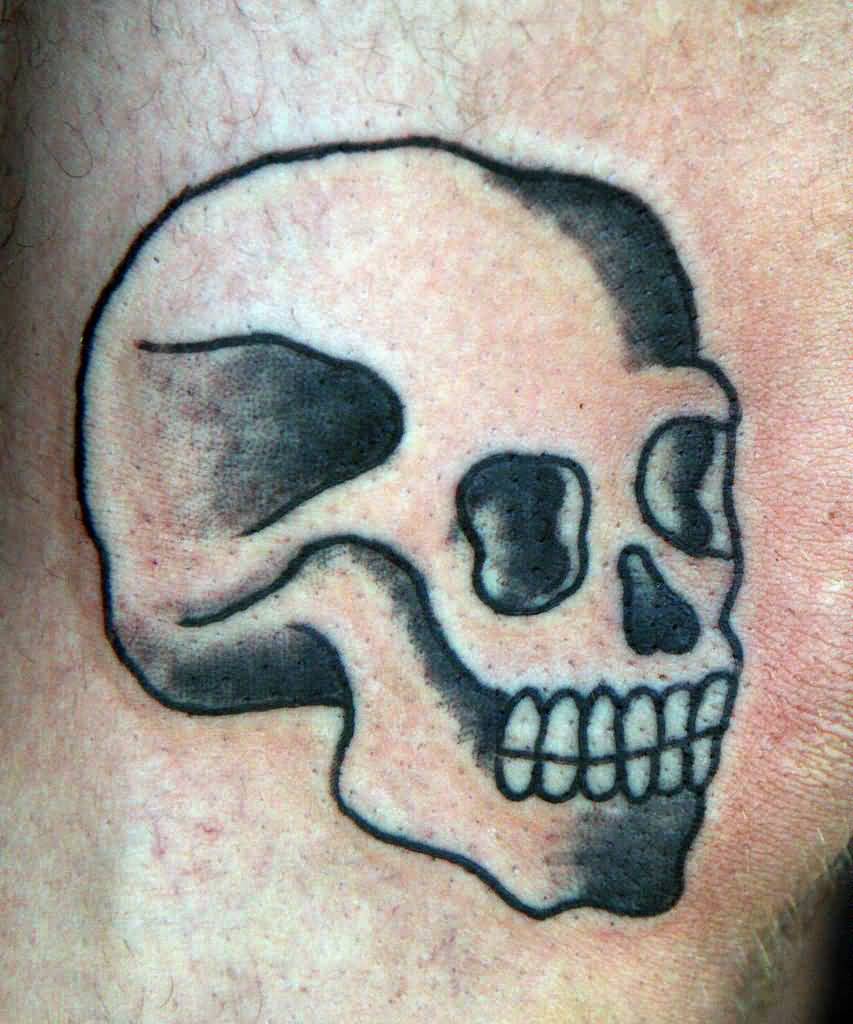 Black and grey shaded skull tattoo on body