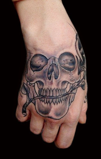 Black and grey shaded skull tattoo with rose on right hand