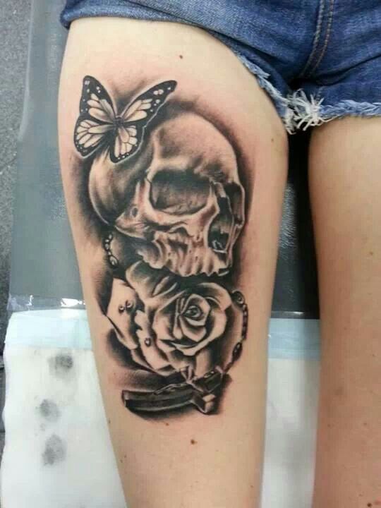 Black and grey shaded skull with rose and butterfly tattoo on right thigh for women