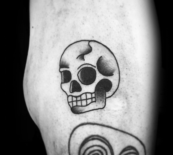Black and grey small traditional skull tattoo on body