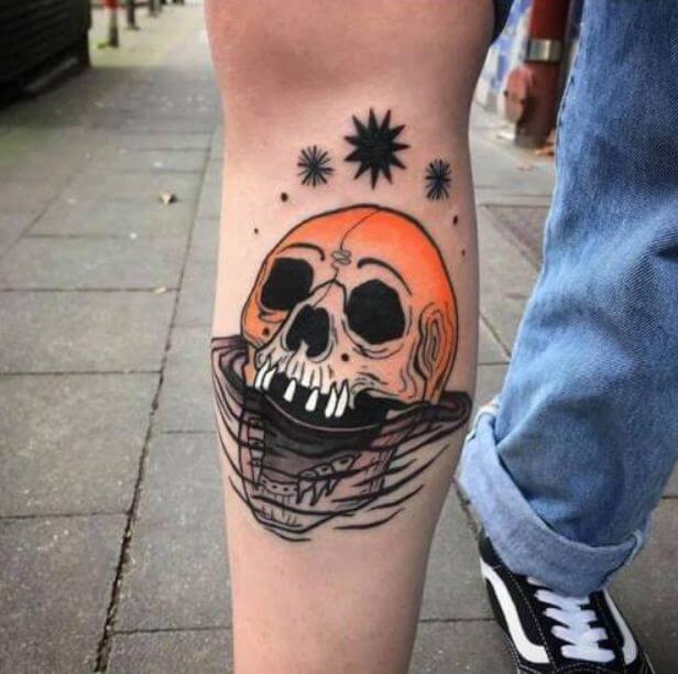 Black and neon traditional skull tattoo on lower leg for women