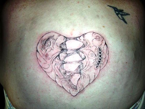 Black and red tearing apart broken heart tattoo on body
