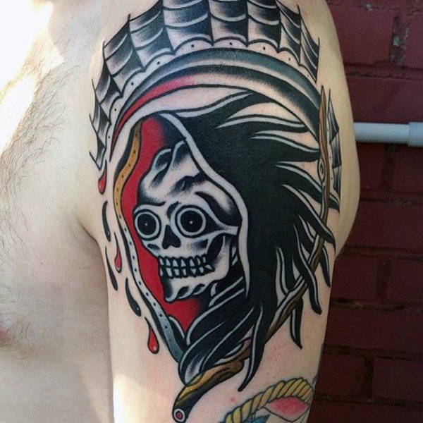 Black and red traditional skull tattoo on upper sleeve