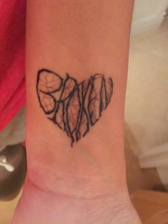 Black broken heart tattoo on inner wrist
