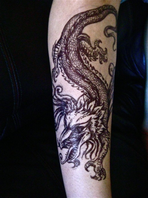Black dragon and snake tattoo design on arm