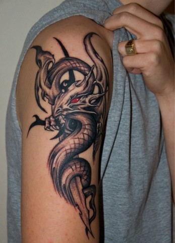 Black evil dragon and snake tattoo on right upper arm