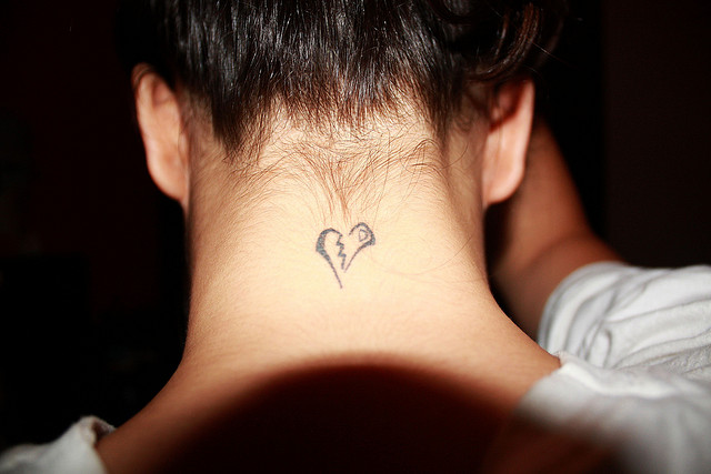 Black outlined broken heart tattoo on nape for men
