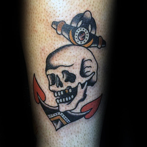 Black shaded anchor and skull traditional tattoo on hand