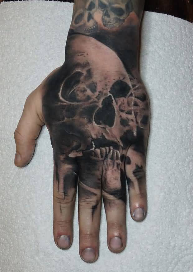 Black shaded hand skull tattoo