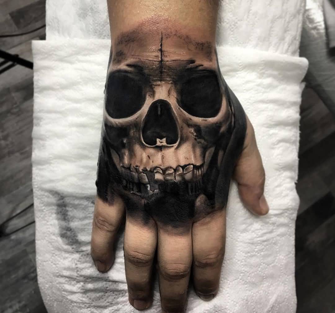 Black shaded realistic skull tattoo on right hand for men