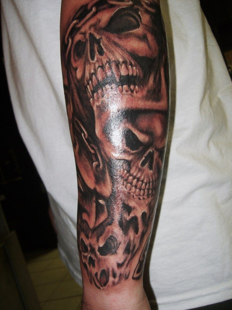 Black shaded skull tattoo on lower sleeve