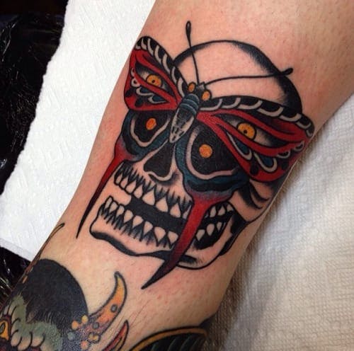 Colored butterfly eyes traditional skull tattoo on body