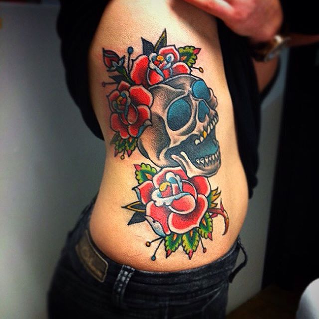 Colored skull and roses tattoo on right upper body