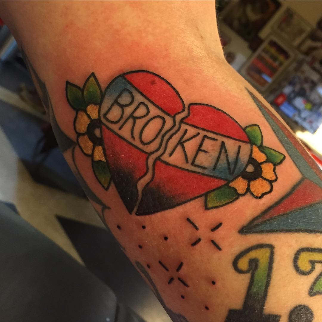 Colored traditional broken heart tattoo on arm