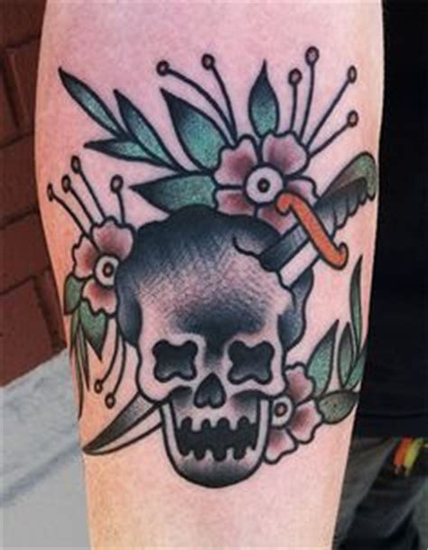 Colored traditional skull and sword with flowers tattoo on hand by Mike Adams