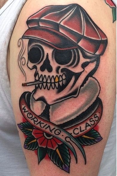 Colored traditional skull tattoo on upper sleeve for men