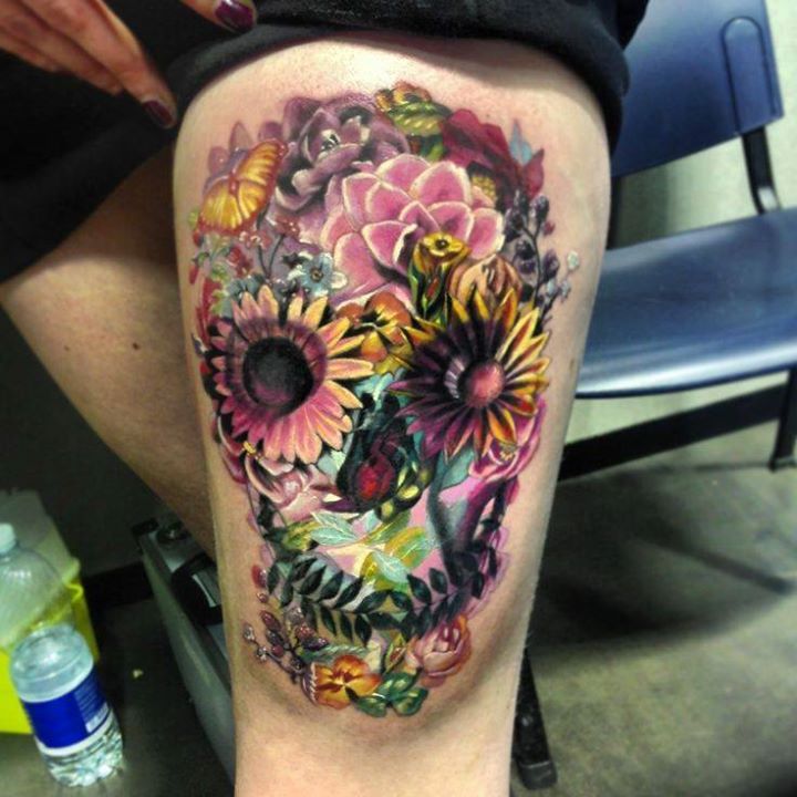 Colorful flower skull tattoo on left thigh