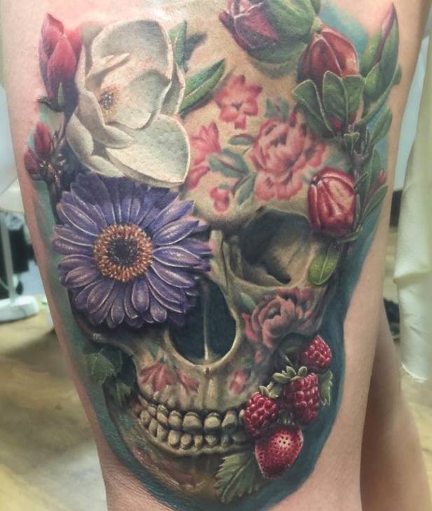 Colorful flower skull tattoo on side thigh for women