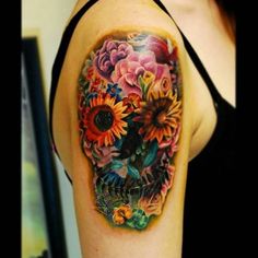 Colorful flower skull tattoo on upper sleeve for women