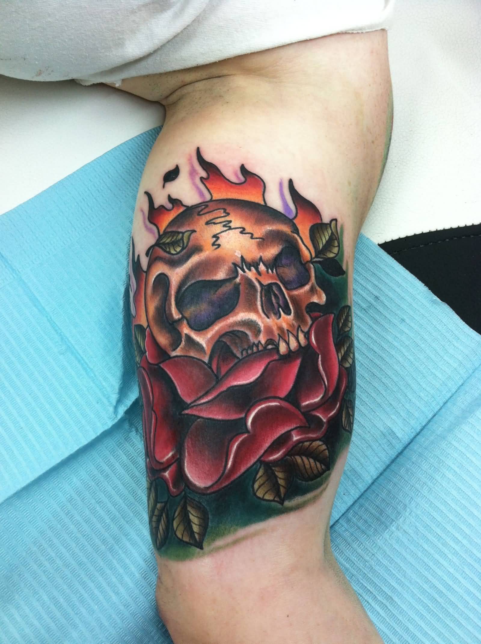Colorful skull and rose tattoo on biceps