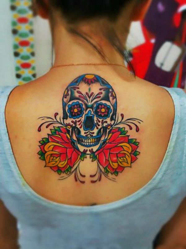 Colorful sugar skull and roses tattoo on upper mid back for women