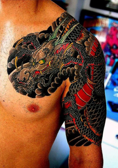 Colored traditional dragon and snake tattoo on left half arm and shoulder of man