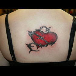 Grey and red barbed wire broken heart tattoo on mid upper back for women