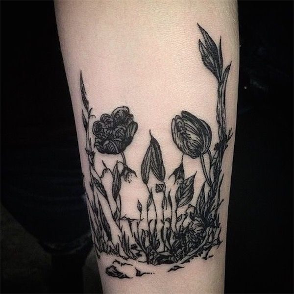 Grey shaded flower skull tattoo on arm