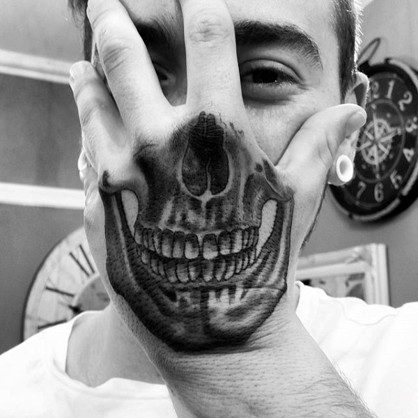 Grey shaded optical illusion skull on hand tattoo
