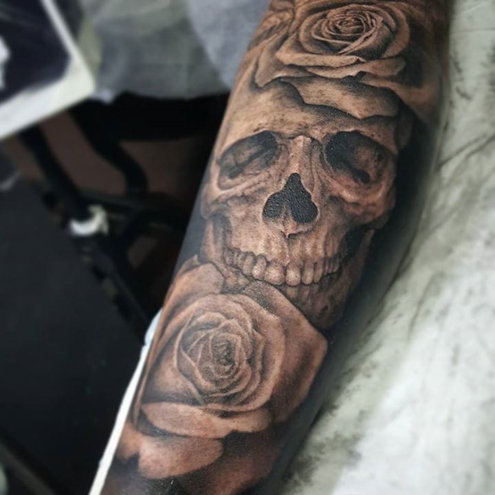 Grey shaded skull and roses tattoo on full forearm by Samm Lacey