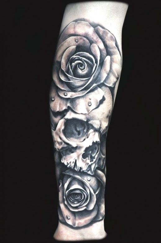 Grey shaded skull and roses tattoo on lower arm