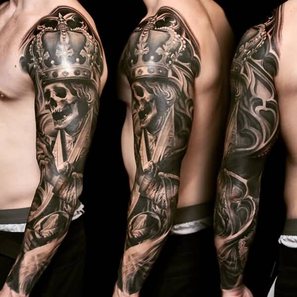 Grey shaded skull with crown tattoo on left full sleeve