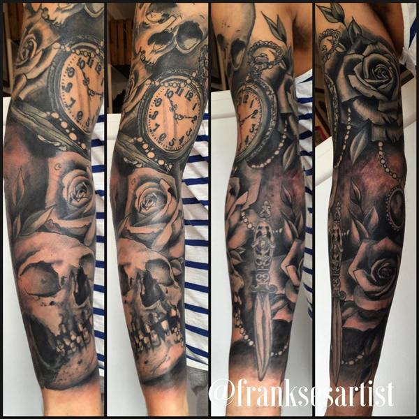 Grey shaded skull with rose and clock tattoo on sleeve