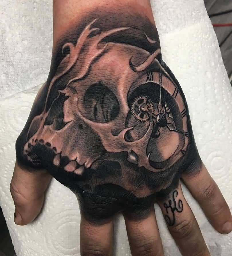 Grey shaded skull with watch tattoo on hand