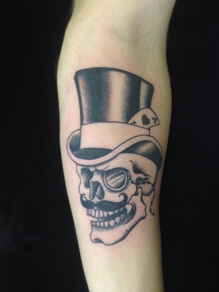 Grey shaded traditional skull tattoo on arm