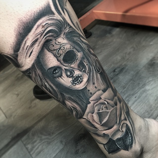 Grey shaded women skull and rose tattoo on upper arm for women