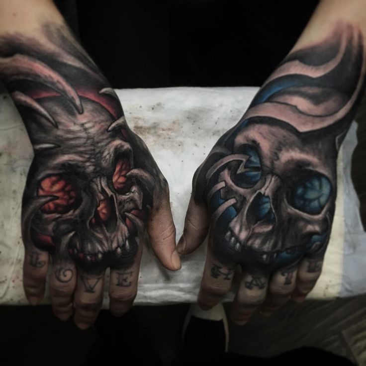 Red and blue skull tattoo on hands