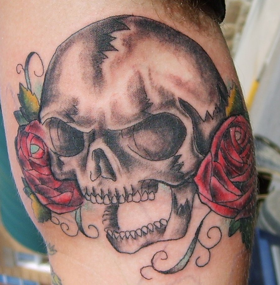 Red and grey shaded skull and roses tattoo on body by Jonny Mistfit