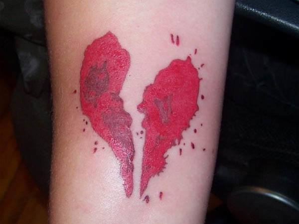 Red bloody broken heart tattoo on arm