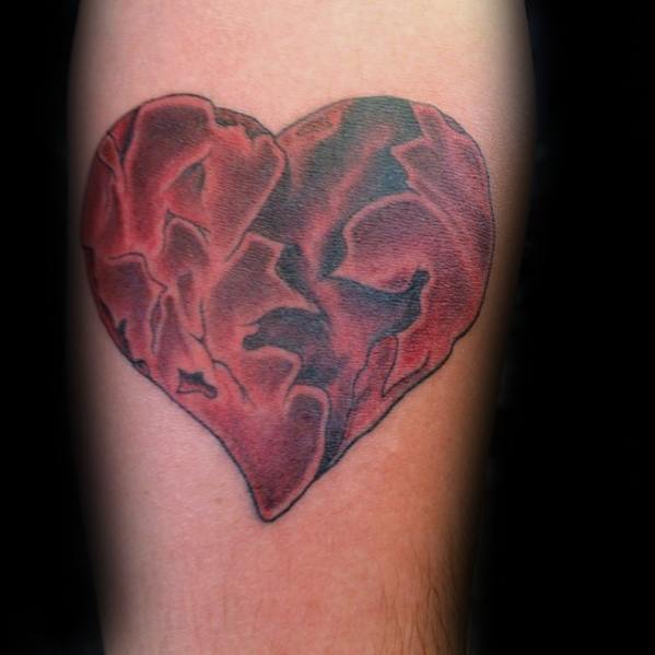 Red ink broken heart tattoo on inner arm