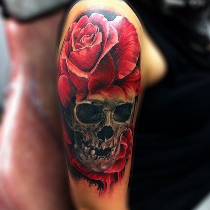Red rose and skull tattoo on upper sleeve for women
