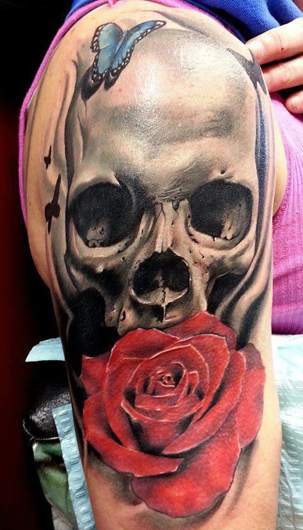 Red rose and skull with butterfly tattoo on upper arm for women