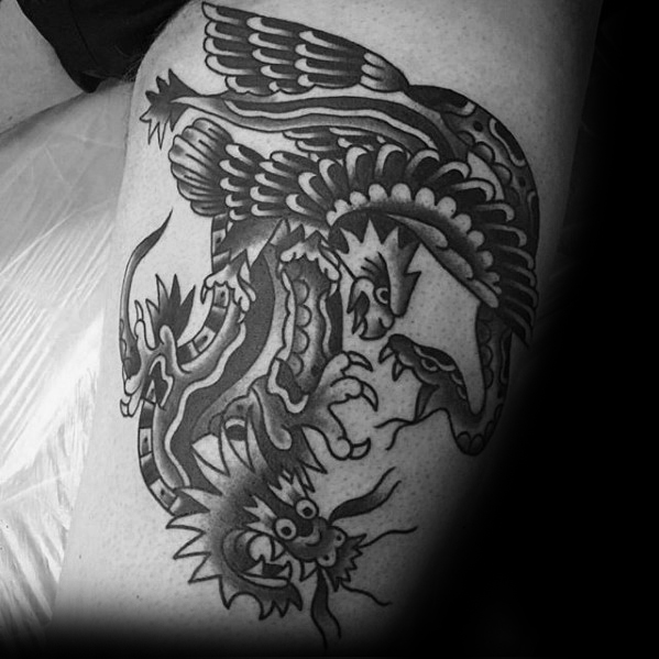 black dragon with eagle and snake tattoo on thigh of man