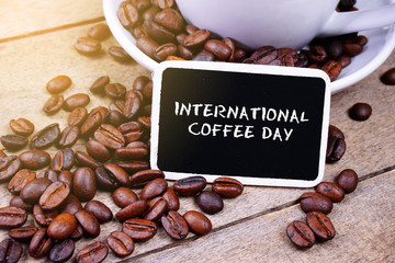 international coffee day written on blackboard over coffee beans