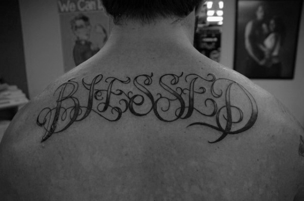 Black and grey shaded simple blessed tattoo on upper back
