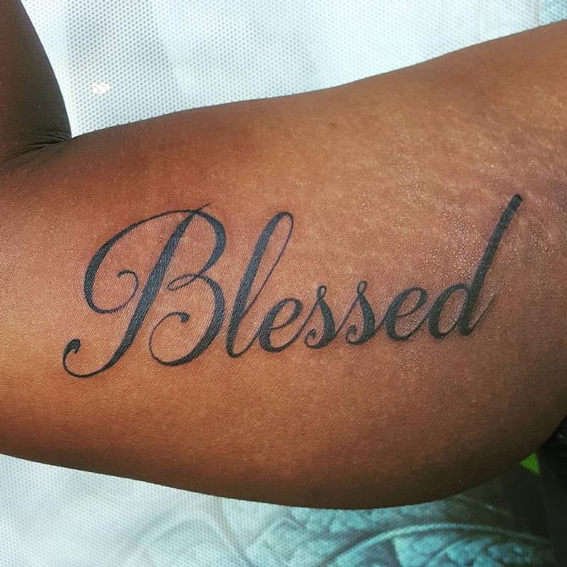 Black simple blessed tattoo on body.