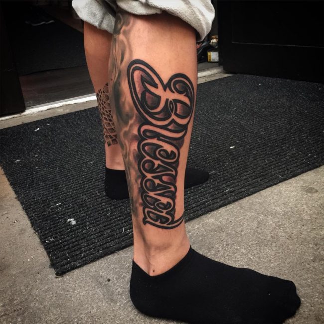 Black simple blessed tattoo on right lower leg