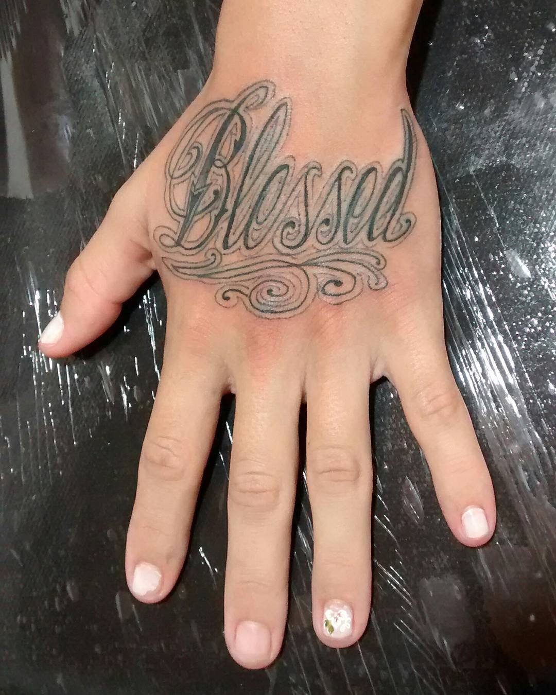Black simple blessed tattoo on upper hand